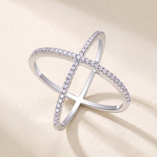 Vellmonto Axis silver ring with crossing moissanite-set bands, front view on a cream background.
