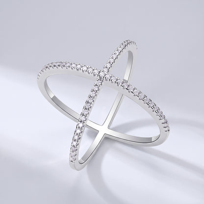 Vellmonto Axis silver crossover ring with moissanite-set bands on a light gray background.