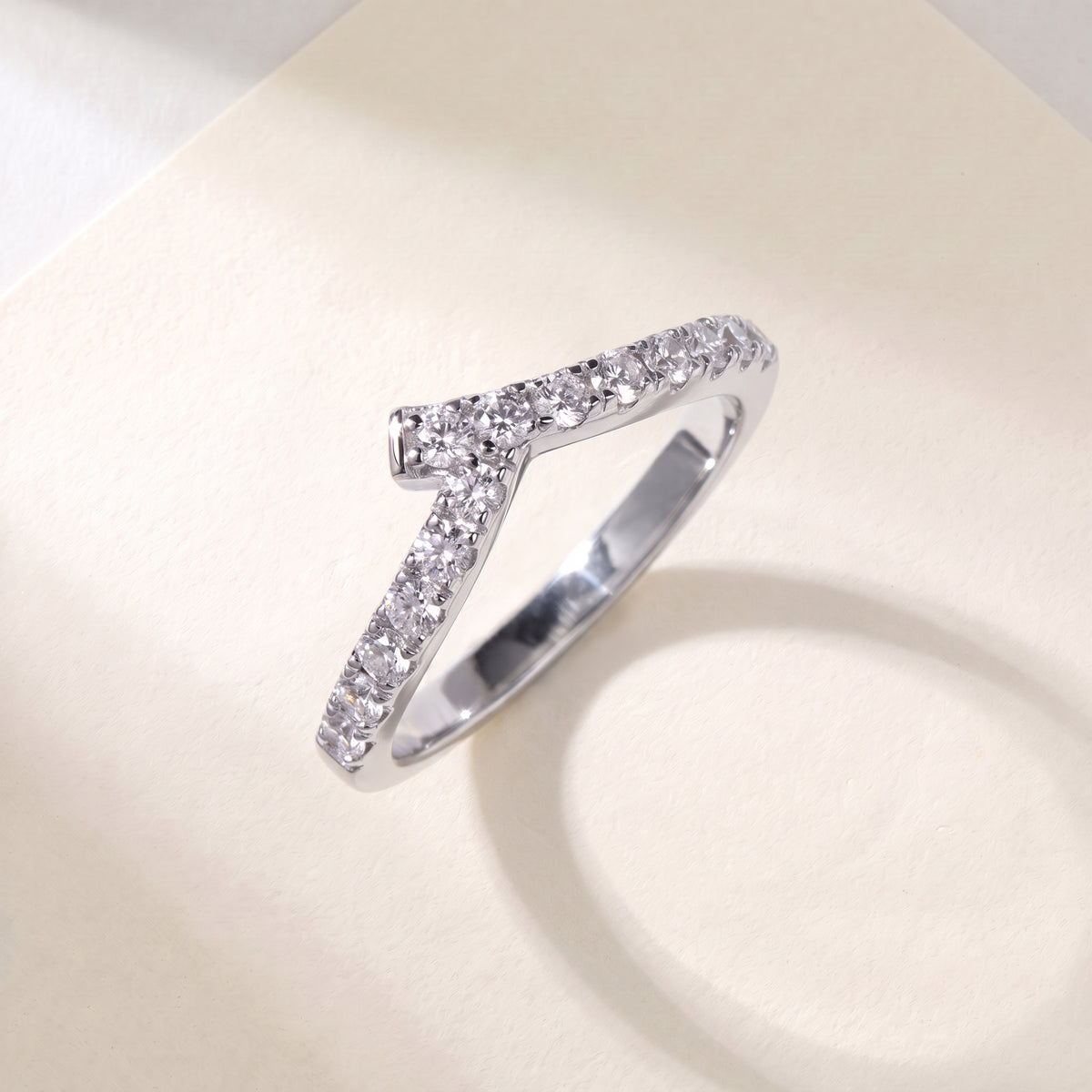 Vellmonto Rush silver chevron ring with moissanite stones, angled front view on a cream background.